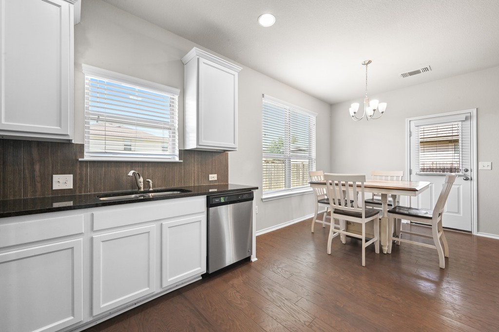 209 Noddy Road Buda, TX 78610 - Photo 13 of 27 Rich wood floors anchor this dining area connected directly to the kitchen.