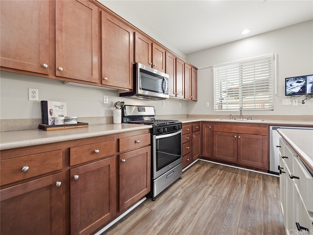 1779 Edmon Way Riverside, CA 92501 - Photo 15 of 63 a kitchen with stainless steel appliances granite countertop wooden cabinets a sink a stove a refrigerator and cabinets