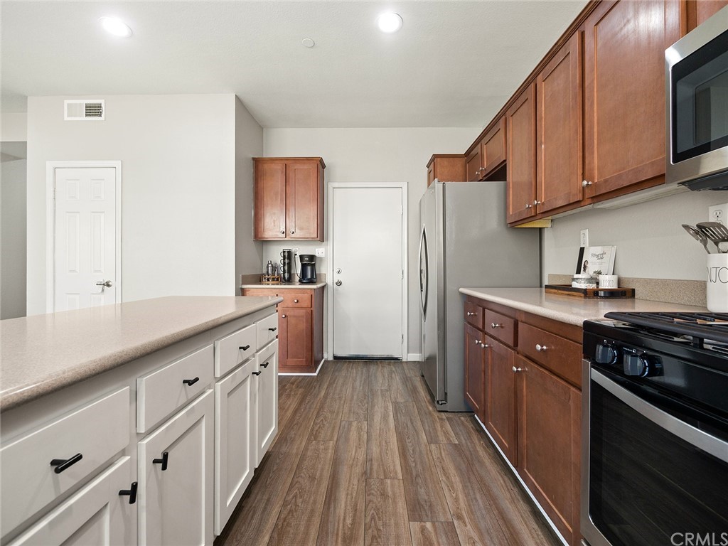 1779 Edmon Way Riverside, CA 92501 - Photo 17 of 63 a kitchen with cabinets stainless steel appliances a sink and wooden floor