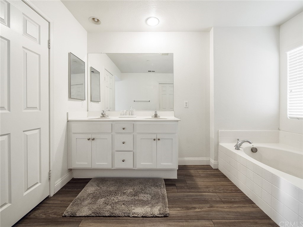 1779 Edmon Way Riverside, CA 92501 - Photo 28 of 63 a spacious bathroom with a double vanity sink a mirror and a bathtub