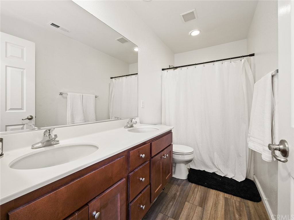 1779 Edmon Way Riverside, CA 92501 - Photo 35 of 63 a bathroom with a double vanity sink toilet and a mirror