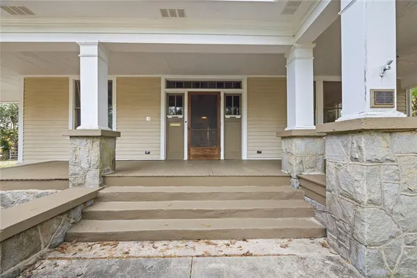 a view of an empty room with wooden floor and a fireplace