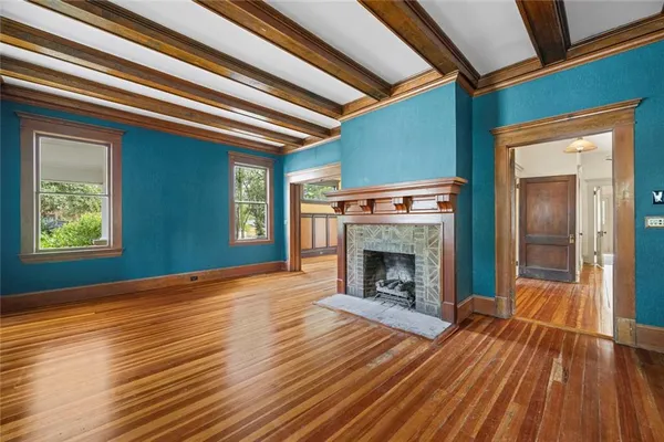 a view of a hallway with wooden floor and a fireplace