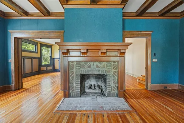 a view of empty room with wooden floor and fireplace