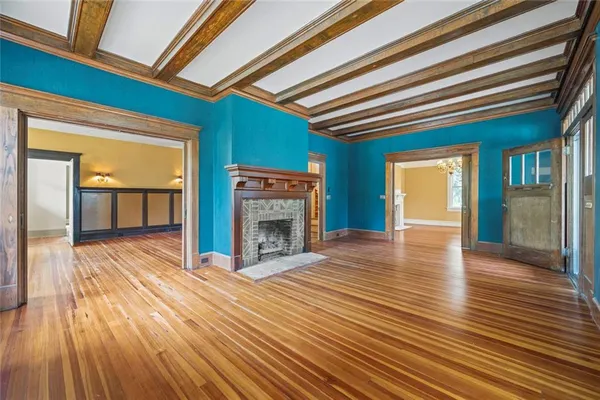 a view of empty room with wooden floor and fireplace
