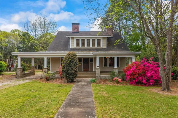a front view of house with yard seating and green space