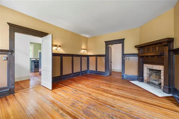 a view of a hallway with wooden floor and a living room