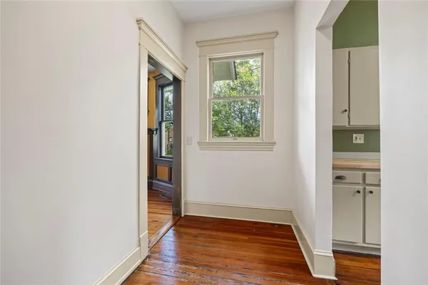 a view of a hallway with wooden floor and staircase