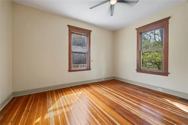 a view of a room with wooden floor and windows