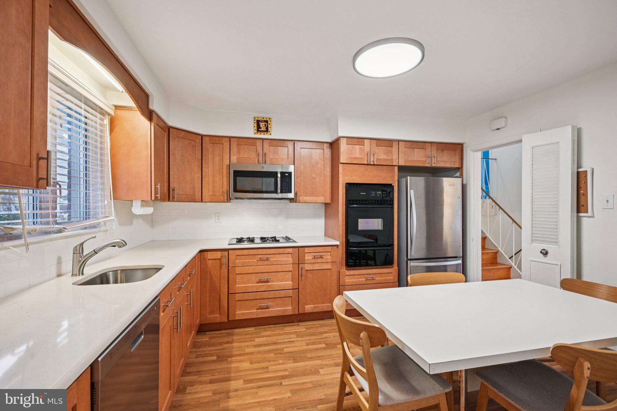 9227 Burbank Road Philadelphia, PA 19115 - Photo 19 of 46 a kitchen with stainless steel appliances granite countertop a sink dishwasher stove refrigerator and cabinets
