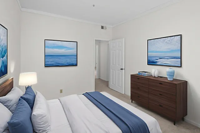 a bedroom with a bed and a lamp on dresser