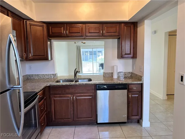 a kitchen with granite countertop a sink and wooden cabinets