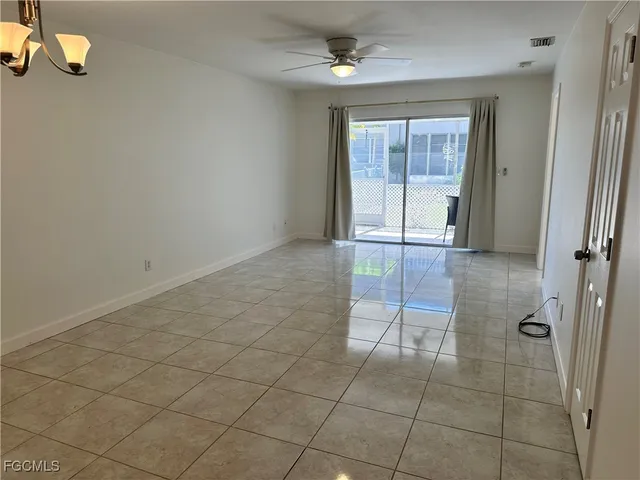 a view of a livingroom with a chandelier fan and windows
