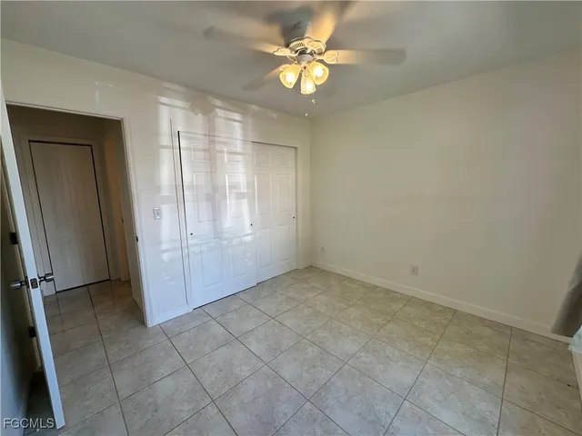 en empty room with windows and fan