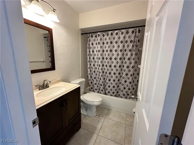 a bathroom with a granite countertop sink toilet and mirror