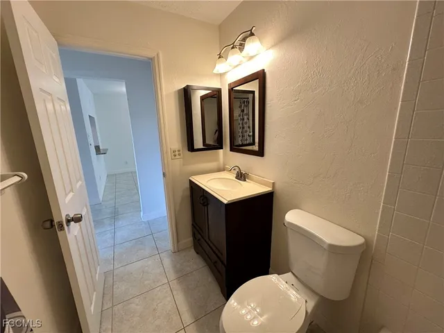 a bathroom with a sink vanity mirror and toilet
