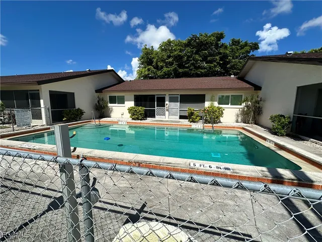 a house view with a sitting space fire pit and outdoor space