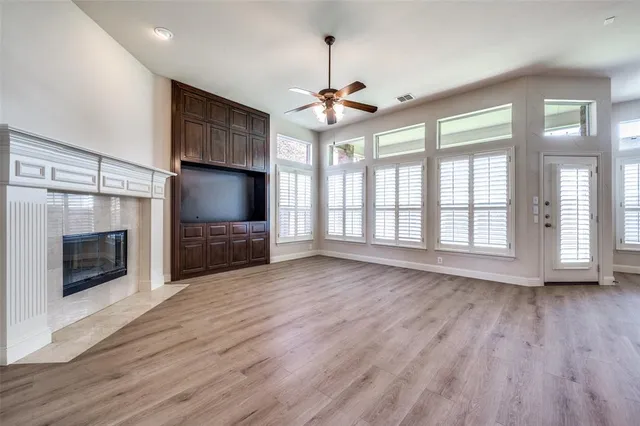 a view of an empty room with a fireplace and a window