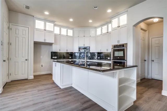 a kitchen with stainless steel appliances granite countertop a refrigerator and a stove top oven