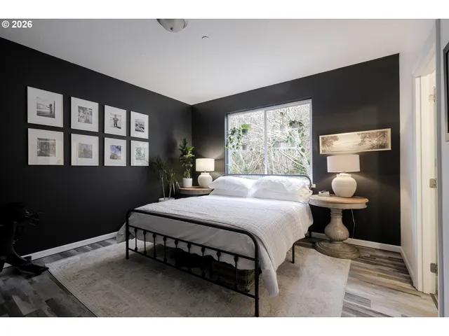 a bedroom with a bed wooden floor and window