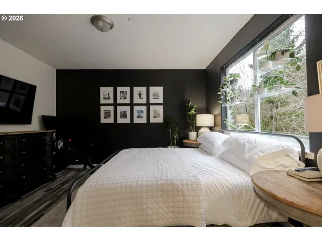 a bedroom with a bed and a large window