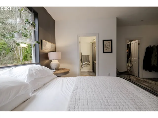 a bedroom with a bed and a flat tv screen on dresser