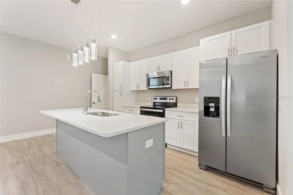 a kitchen with kitchen island a refrigerator stove and sink