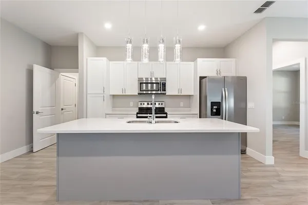 a kitchen with refrigerator cabinets and wooden floor