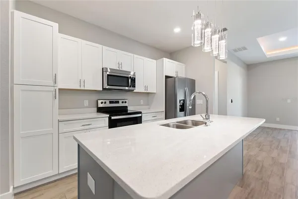 a kitchen with kitchen island a sink stove and refrigerator