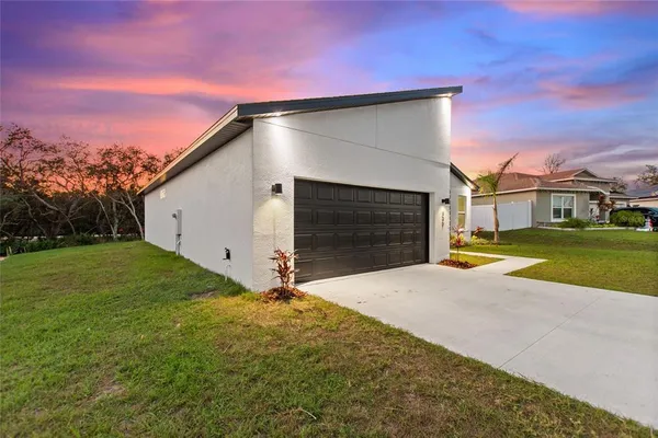 a backyard of a house with plants and a yard