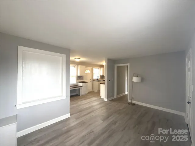 a view of a livingroom with wooden floor and a window