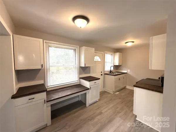 a kitchen with a refrigerator and white cabinets