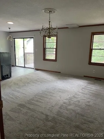 an empty room with windows and ceiling fan