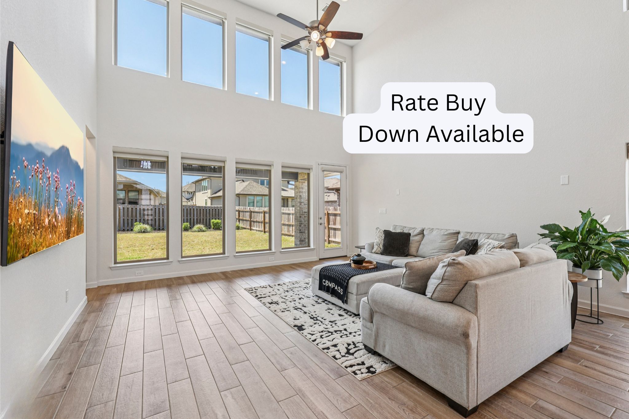 1140 Bryson Rdg Trail Leander, TX 78641 - Photo 1 of 39 Double-height living area featuring wood-finish flooring, a ceiling fan, and large windows with backyard views