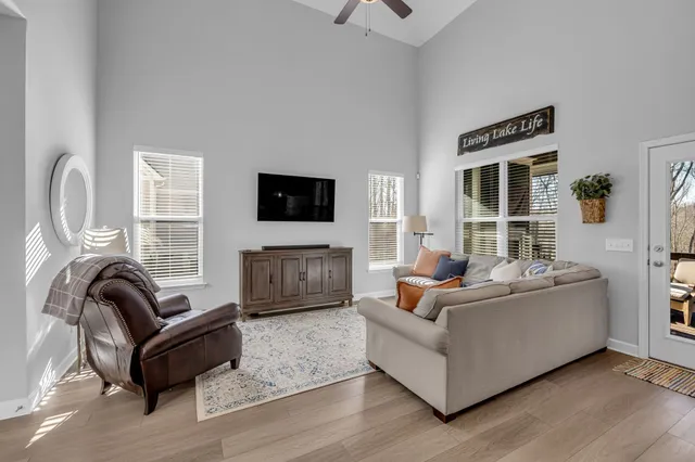 a living room with furniture a flat screen tv and a window
