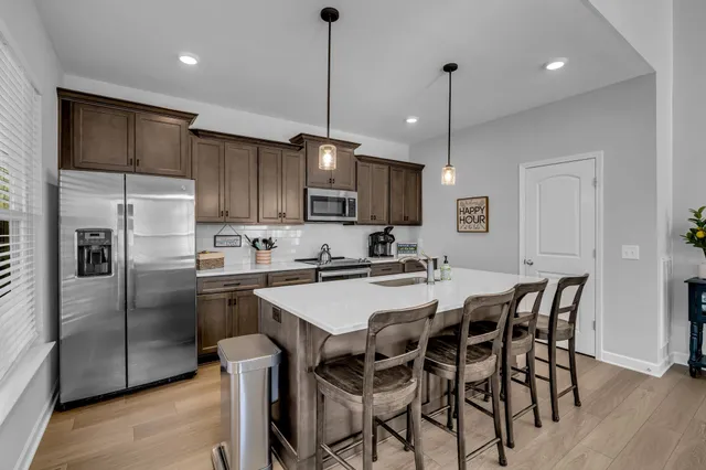 a kitchen with stainless steel appliances granite countertop a sink a stove and a refrigerator