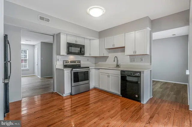 a kitchen with granite countertop a sink and steel appliances