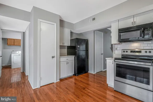 a kitchen with stainless steel appliances a stove a refrigerator and a microwave