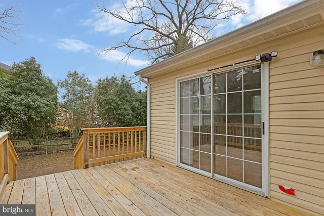 a view of a deck with wooden floor and fence and a floor to ceiling window