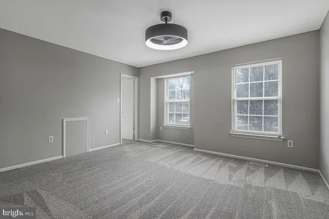 an empty room with windows and closet