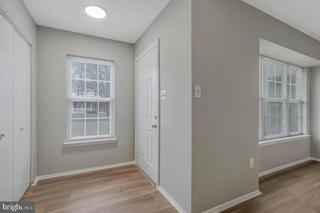 an empty room with windows and closet