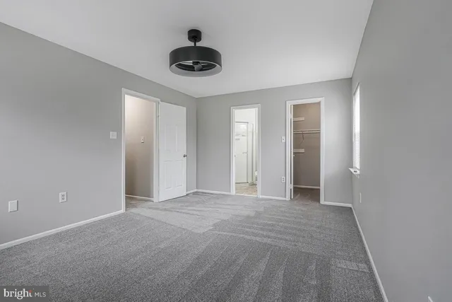 a view of an empty room with a ceiling fan