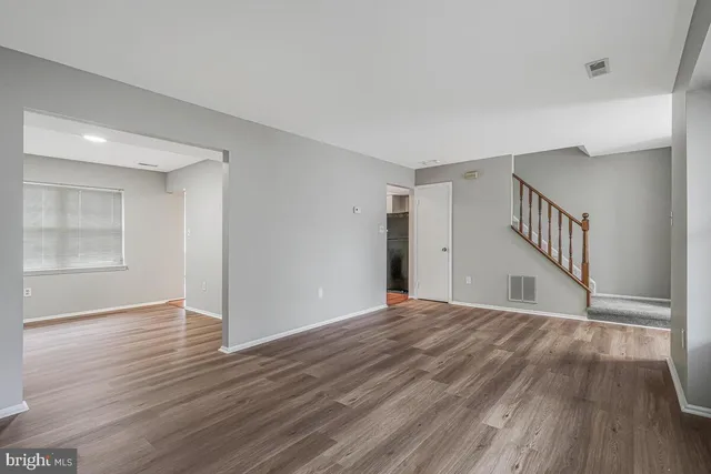 a view of empty room with wooden floor and windows