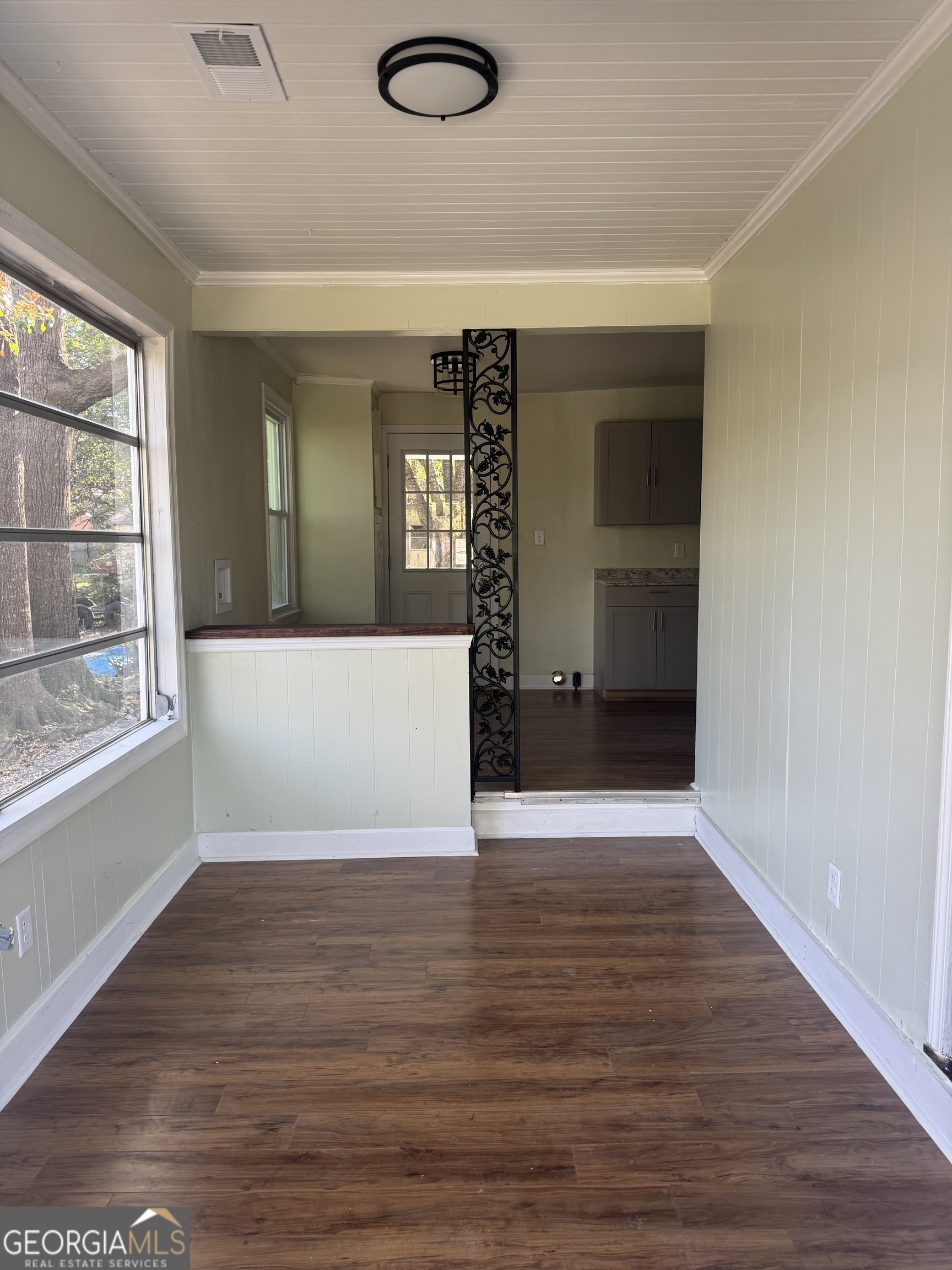 906 Central Avenue Dublin, GA 31021 - Photo 2 of 15 a view of an empty room with wooden floor and a window
