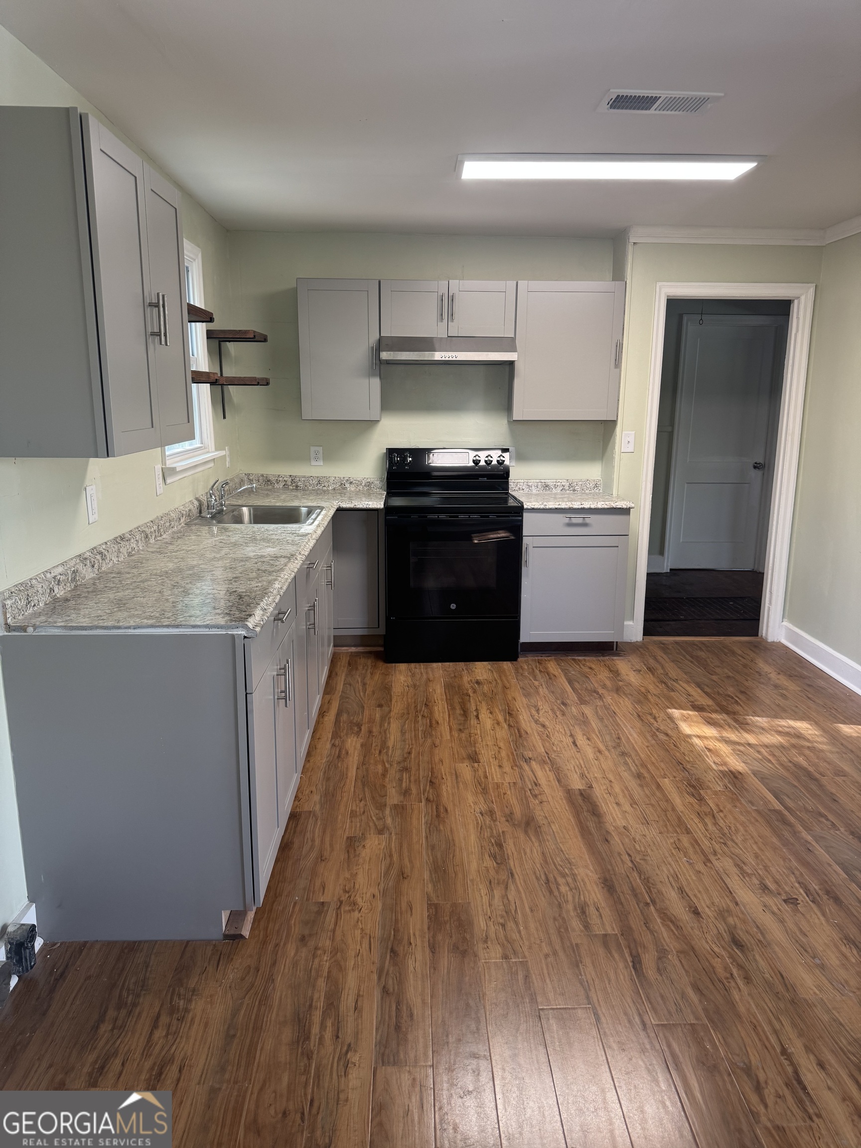 906 Central Avenue Dublin, GA 31021 - Photo 4 of 15 a large kitchen with stainless steel appliances granite countertop a stove a sink and a refrigerator