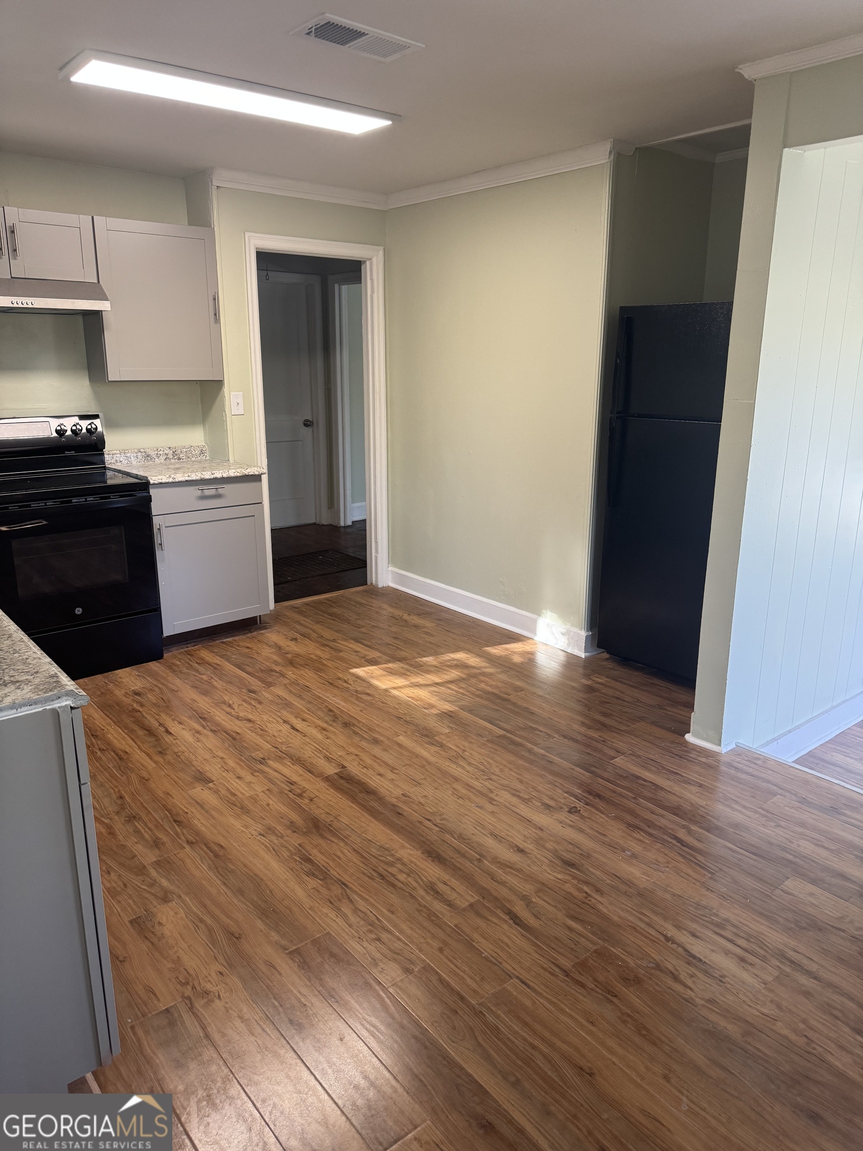 906 Central Avenue Dublin, GA 31021 - Photo 5 of 15 a view of a kitchen with wooden floor and electronic appliances
