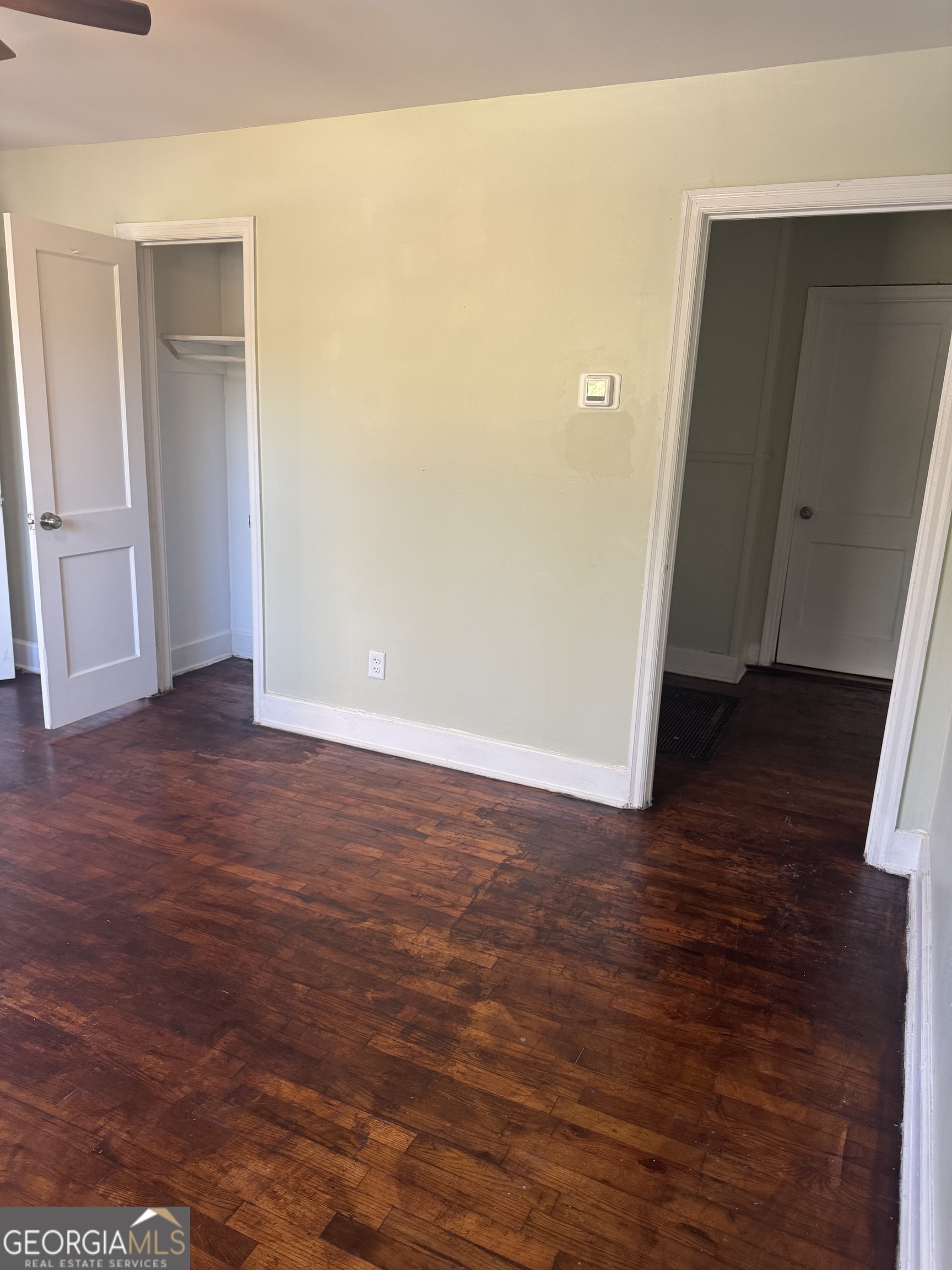 906 Central Avenue Dublin, GA 31021 - Photo 6 of 15 an empty room with wooden floor and entrance