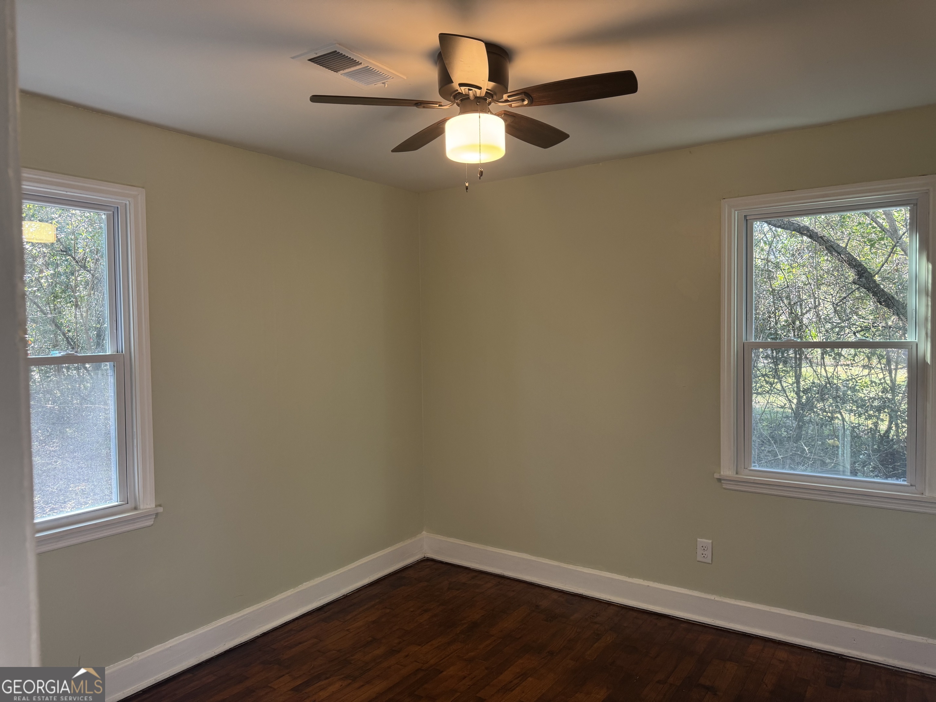 906 Central Avenue Dublin, GA 31021 - Photo 10 of 15 an empty room with wooden floor and windows