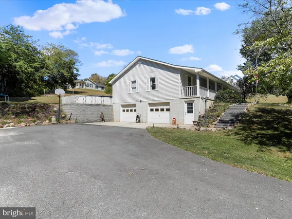a view of a house with a yard and large tree