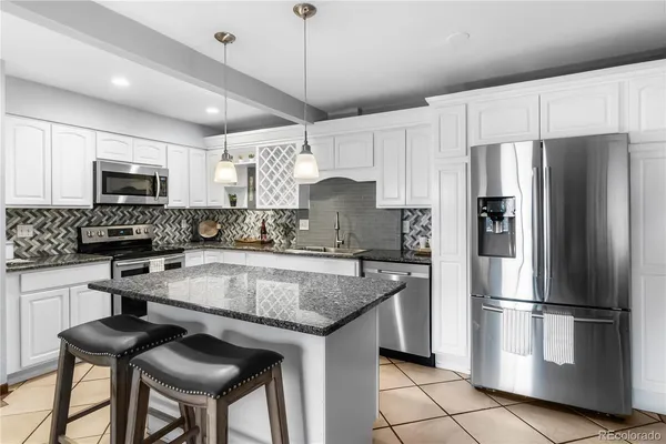 a kitchen with kitchen island a counter space a sink appliances and cabinets